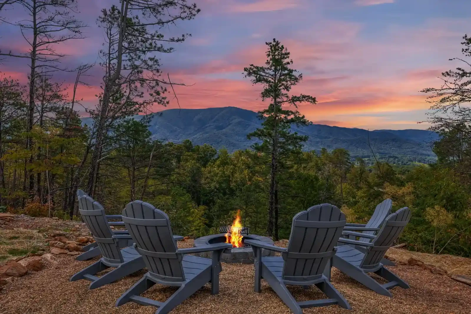 chairs around fire pit with mountain view at sunset